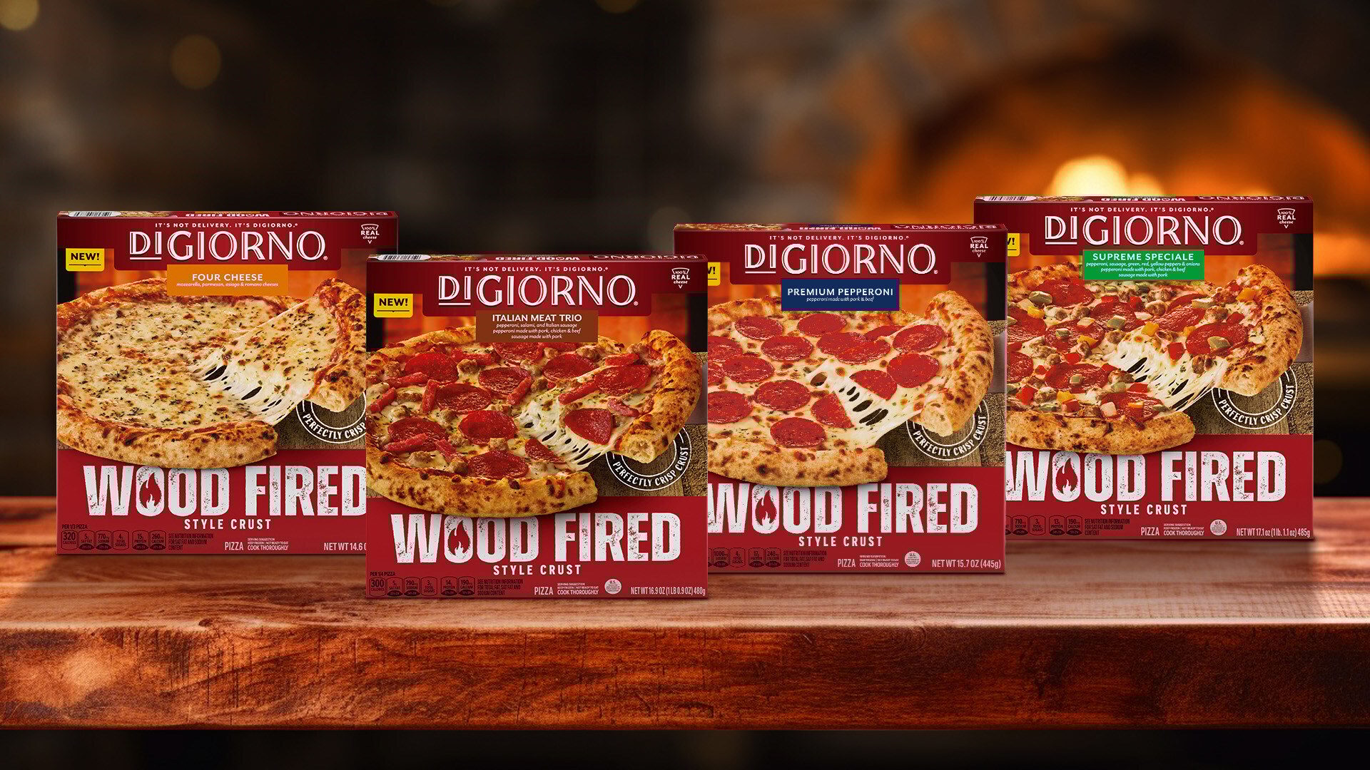 Four DiGiorno Wood Fired pizza boxes (various flavors) on a wooden table.