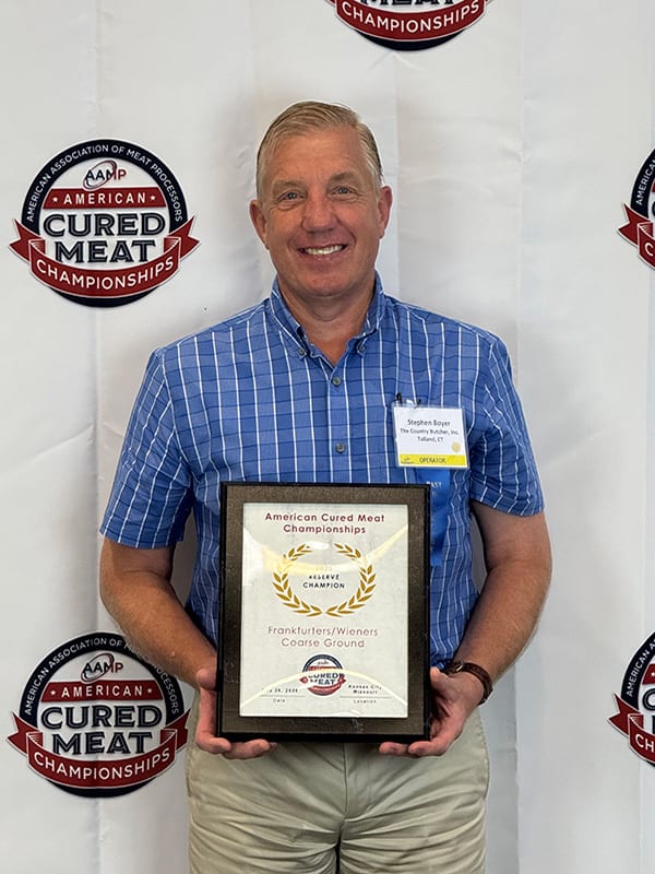 Stephen Boyer holds a Reserve Champion award for Frankfurters at American Cured Meat Championships.