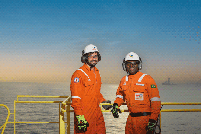Hard hat, High-visibility clothing, Water, Sky, Workwear, Helmet, Gesture, Travel