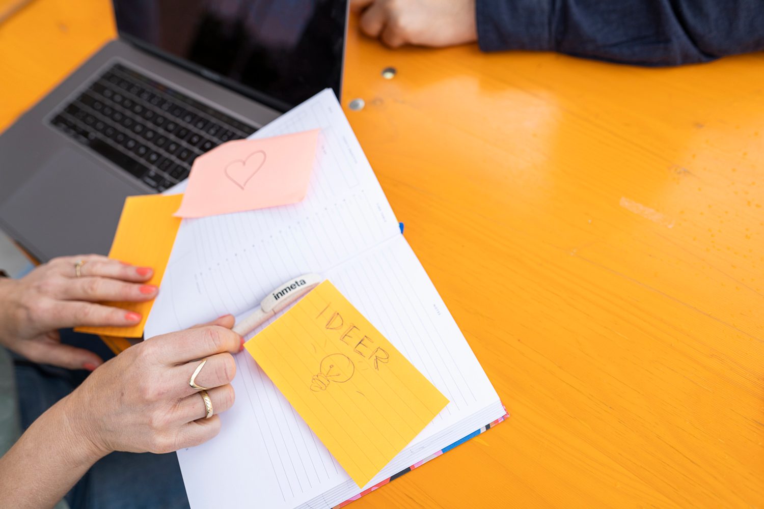 Material property, Hand, Laptop, Orange, Computer, Yellow, Finger, Font, Handwriting, Table