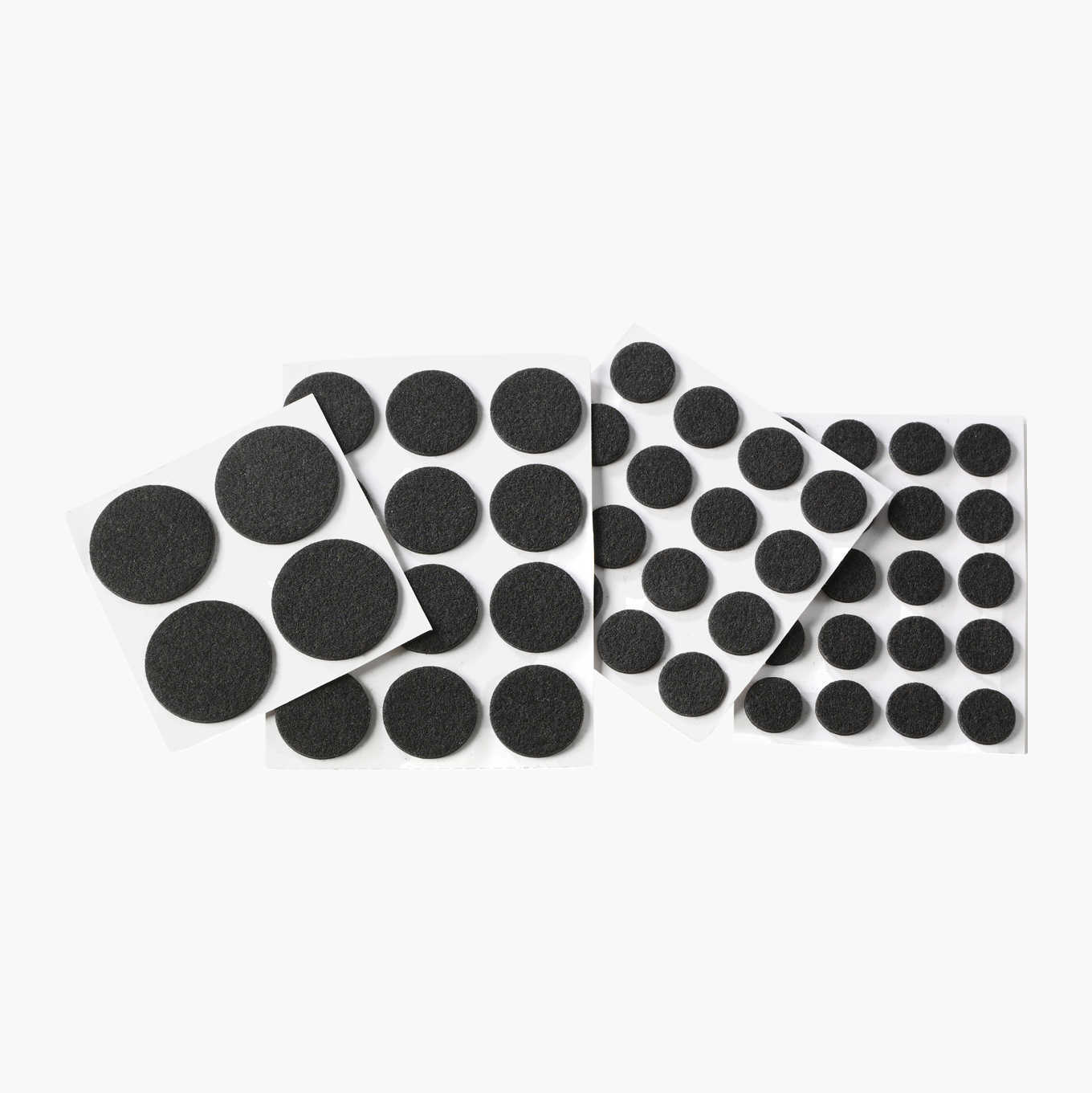 Black circular felt furniture pads on white adhesive sheets.
