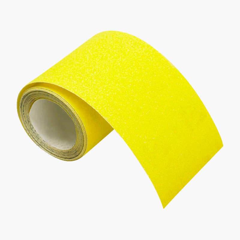 A bright yellow roll of anti-slip tape is partially unrolled, showcasing its gritty texture against a white background.