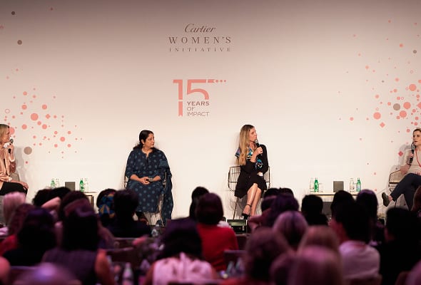 Four women panelists on stage for the Cartier Women's Initiative event, with audience in foreground.