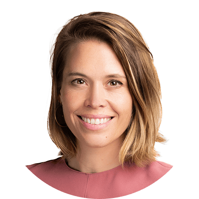 Smiling woman with brown hair in a pink top. Professional headshot.