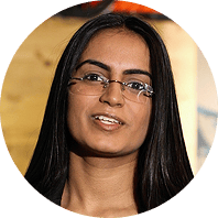 Young woman with dark hair and glasses, smiling.