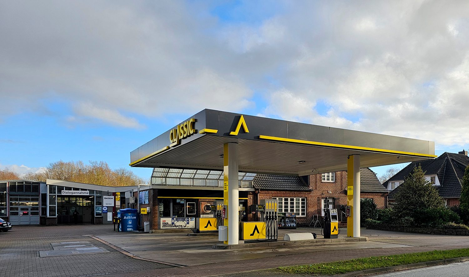 An outdoor shot of a Classic brand gas station with pumps, canopy, and car service bays.