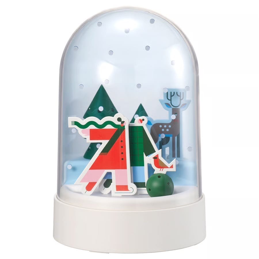 Stylized winter snow globe with two figures, a deer, and trees inside.
