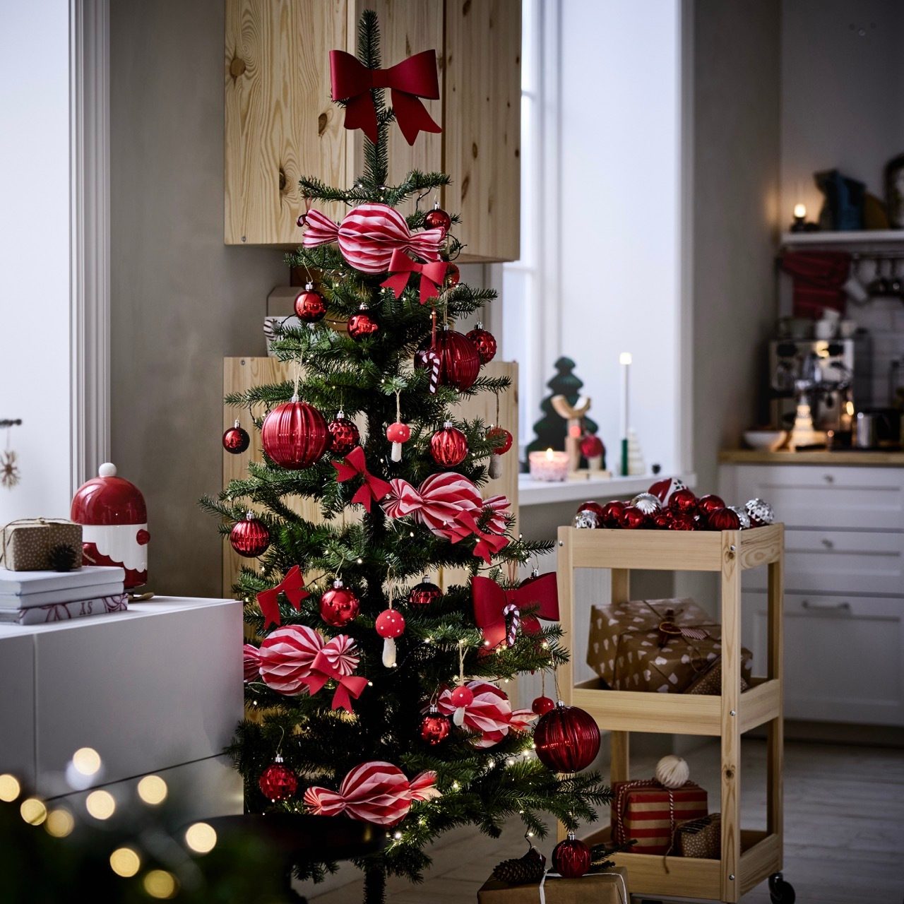 A festive Christmas tree with red and white decorations and lights in a cozy home.