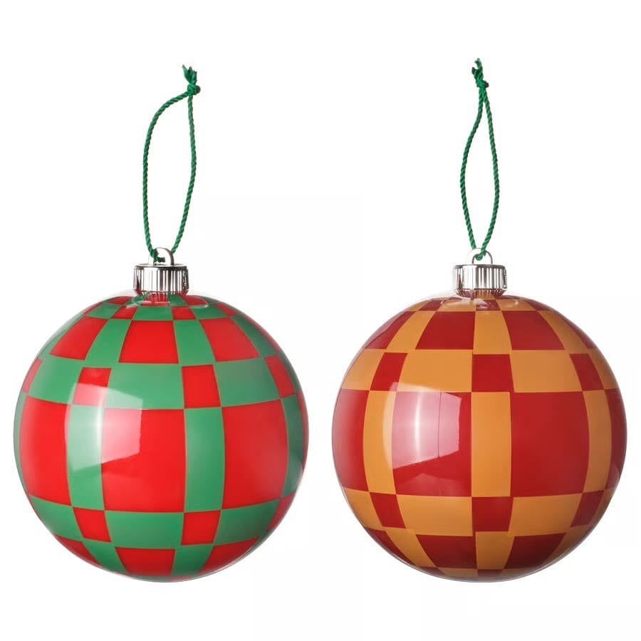 Two checkered Christmas ornaments: one red and green, one red and orange, both with green strings.