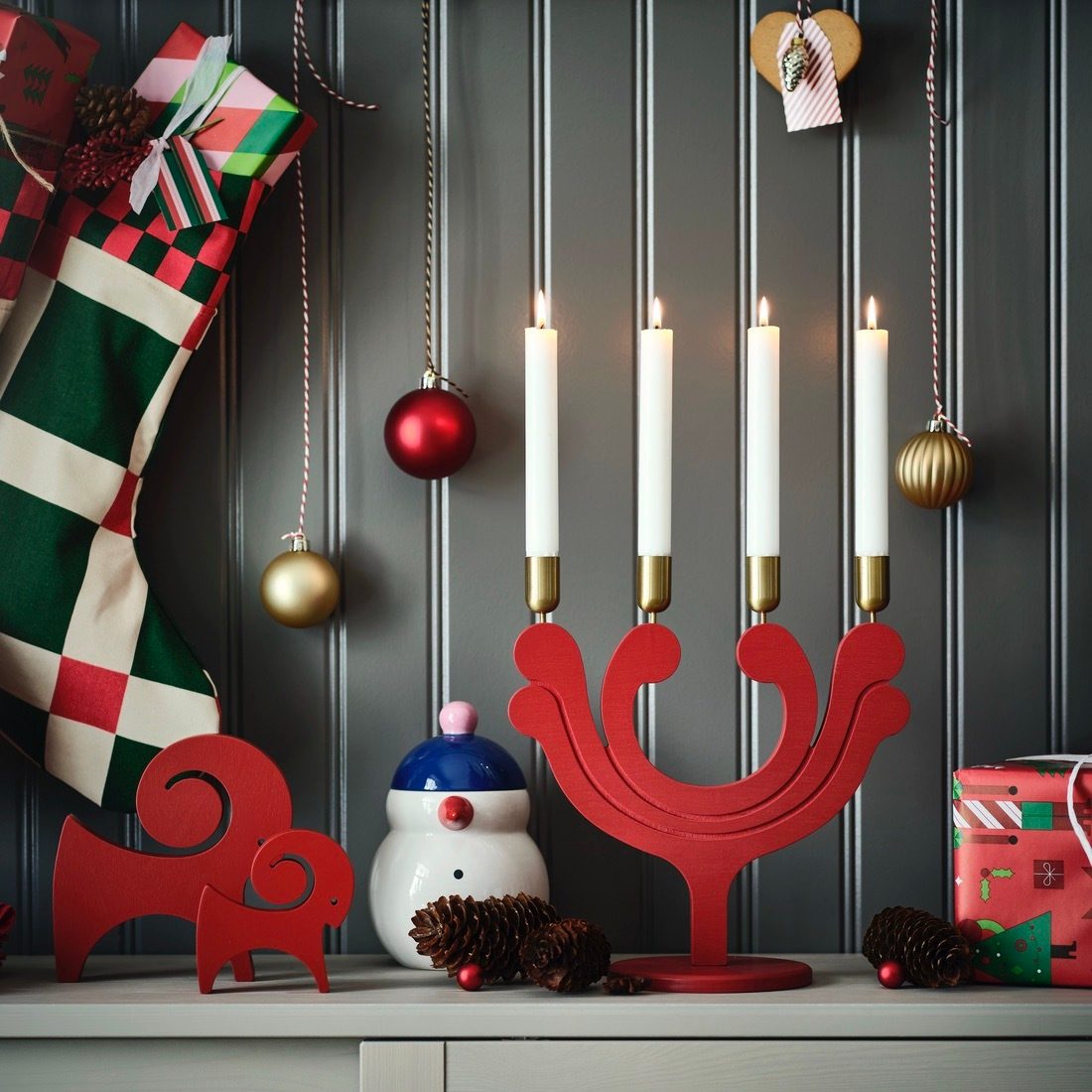 Christmas decorations: red 4-candle holder with lit candles, festive stocking, ornaments, and figures.