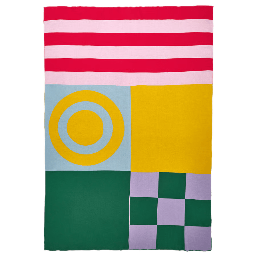 Geometric blanket: red/pink stripes, yellow target on blue, solid yellow, green, purple checkerboard.