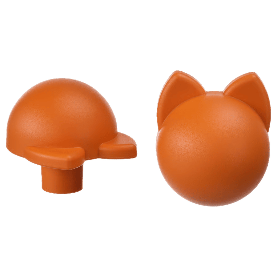 Orange toy parts: a domed piece with tabs, and a cat's head.
