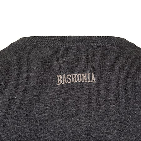 Close-up of a dark gray knitted fabric featuring the word "BASKONIA" embroidered in light brown.