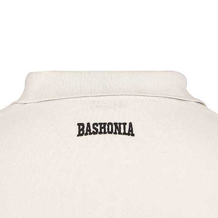 Close-up of the back of a white polo shirt with the word "BASHONIA" embroidered in black on the collar area.