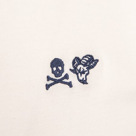 Blue embroidered skull and crossbones with a ram head design on a cream-colored fabric.