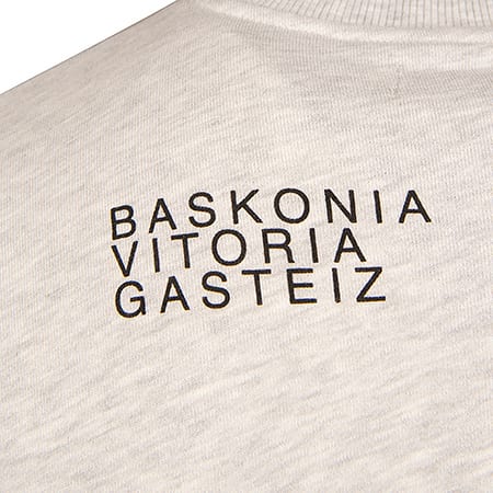 Close-up of light grey fabric with "BASKONIA VITORIA GASTEIZ" text printed in black.