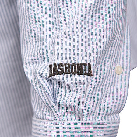 Blue and white striped shirt sleeve with "BASHONIA" embroidered in dark letters and a small white button.