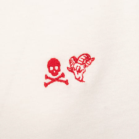 Red embroidered skull and crossbones with a winged ram's head on a white fabric.