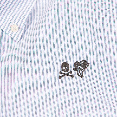 Close-up of blue and white striped fabric with embroidered skull and crossbones and a ram's head.