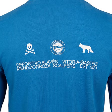 Back of a blue long-sleeve shirt with white Deportivo Alavés logo, skull, fox, and associated text.