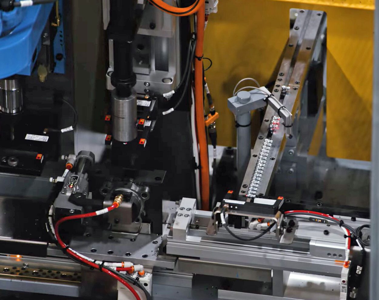 Industrial automation: automated machine with feeder and pneumatic components.