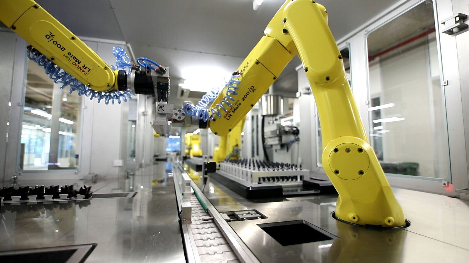 Yellow industrial robots on an assembly line.