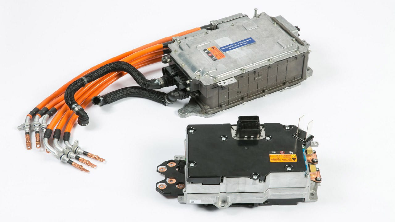 Two automotive power electronics units with attached orange high-voltage cables on a white background.