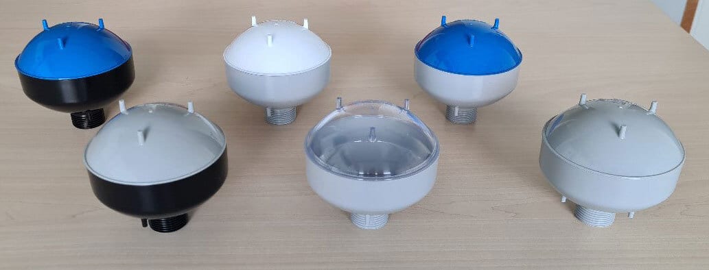 Six dome-shaped devices with threaded bases; blue, black, white, grey, clear colors.