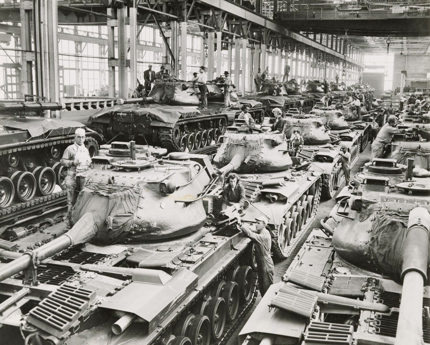 Black and white photo of an early Cold War tank factory with many M47 Patton tanks and workers.
