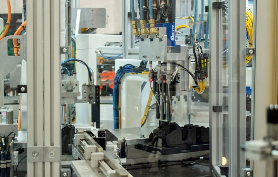 Automated industrial assembly machine with various mechanical, electrical, and pneumatic components.