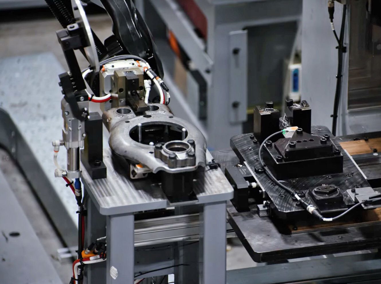 Robotic arm working on a metal car part.