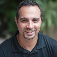 Smiling man with dark hair and goatee.