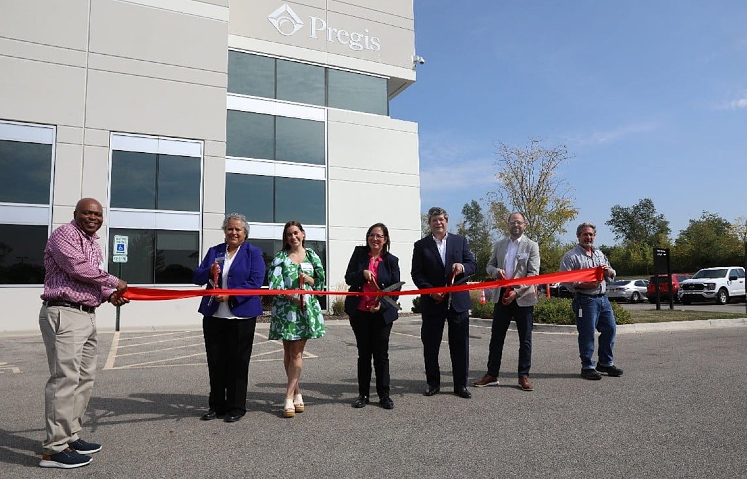 People posing for ribbon cutting at Pregis facility in Elgin