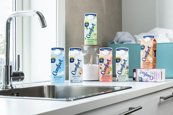 Comfort fabric softener cartons in various colors and scents on a counter next to a sink.