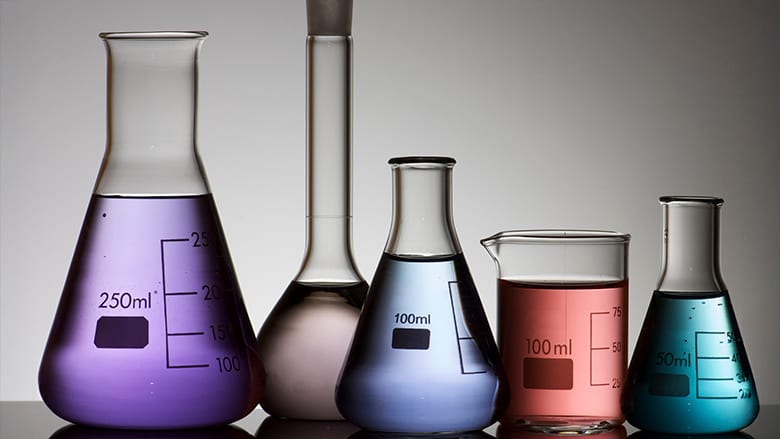 five laboratory flasks on a white backlight 