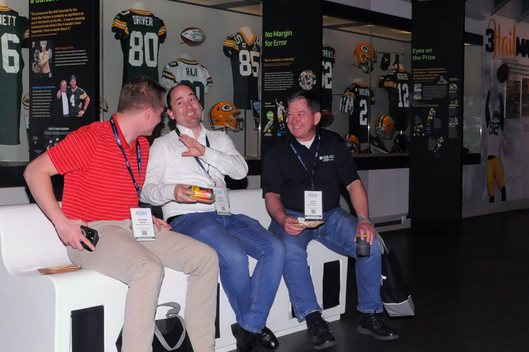 Attendees talking with Packers display case in background