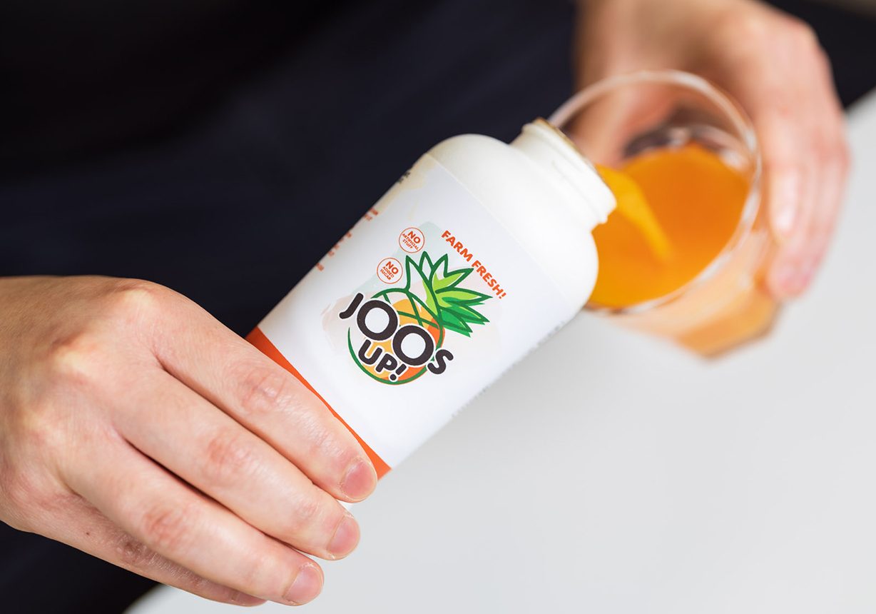 Person pouring juice from a fiber-based bottle
