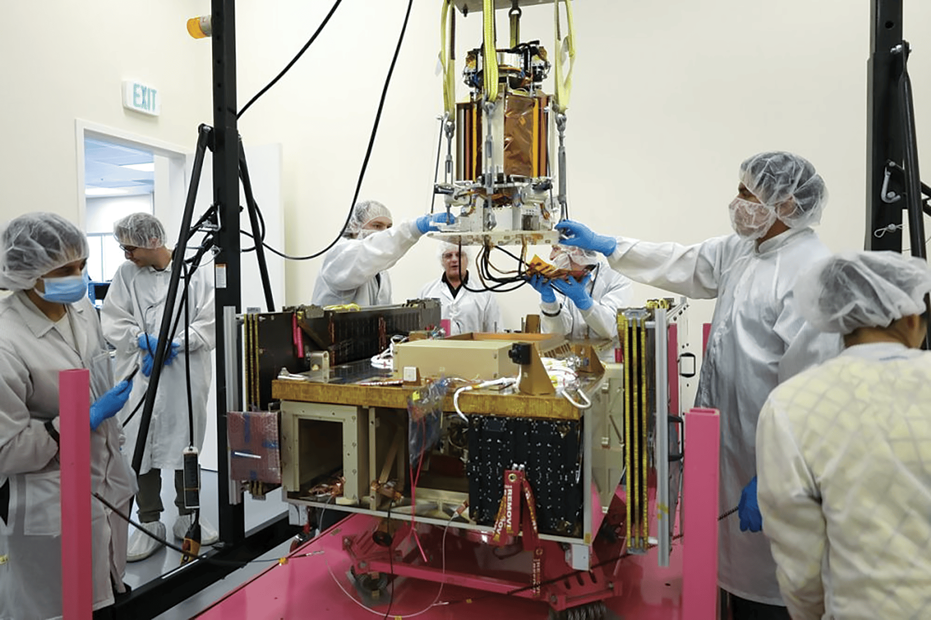 Engineers lower a portion of the Space Solar Power Demonstrator onto spacecraft