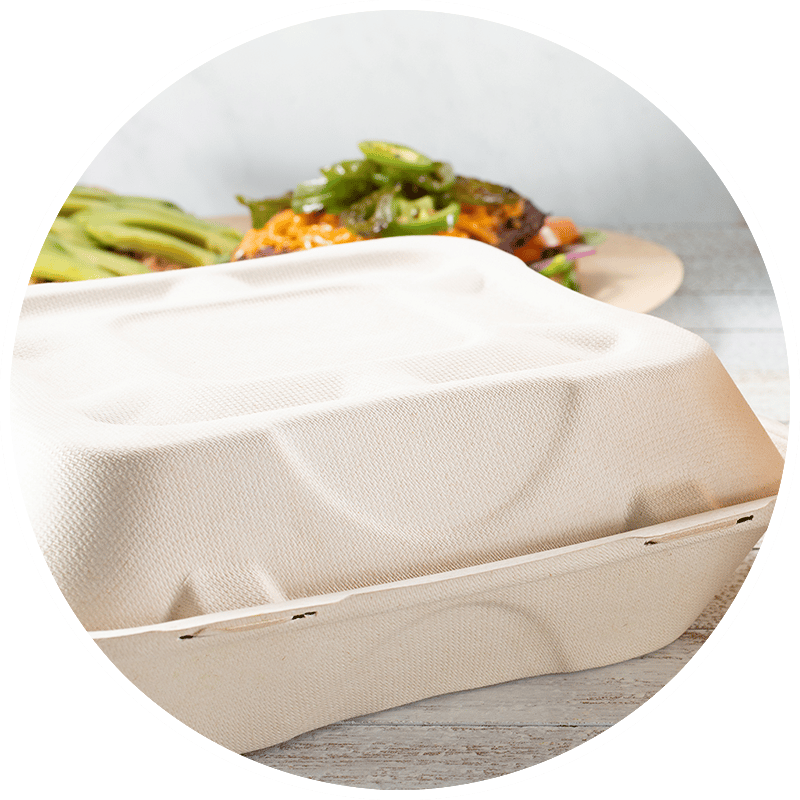 Molded fiber takeout container with lid, food blurred in background.