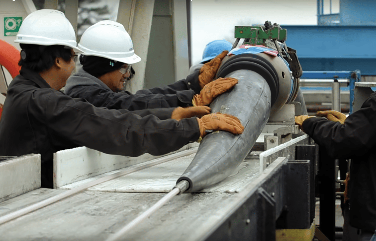 Workers position a submarine fiber-optic cable for installation