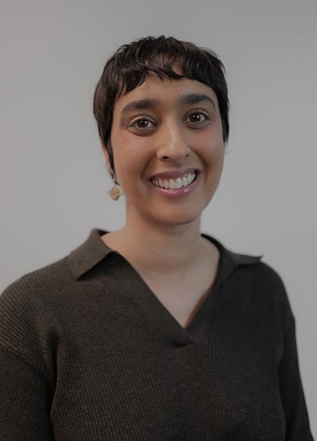 Smiling woman with short dark hair and a dark top.