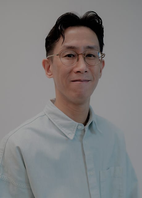Man with glasses and light blue shirt smiling.