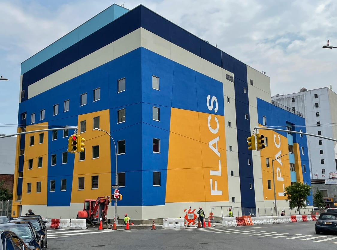 Vibrant blue and orange building with "FLACS" and "LPAC" text, with street construction below.