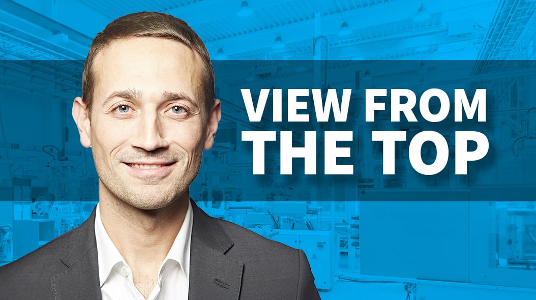 Smiling man, 'VIEW FROM THE TOP' text, blue industrial background.