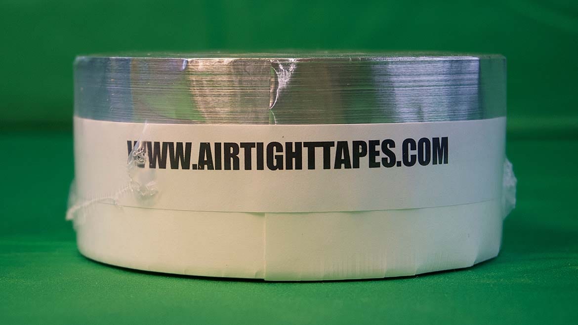 Roll of white tape with 'WWW.AIRTIGHTTAPES.COM' label, on a green background.