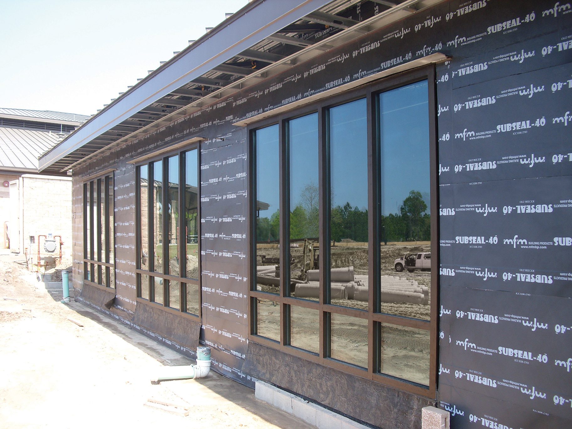 Side of a building under construction, with windows and "SUBSEAL-40" waterproofing membrane.
