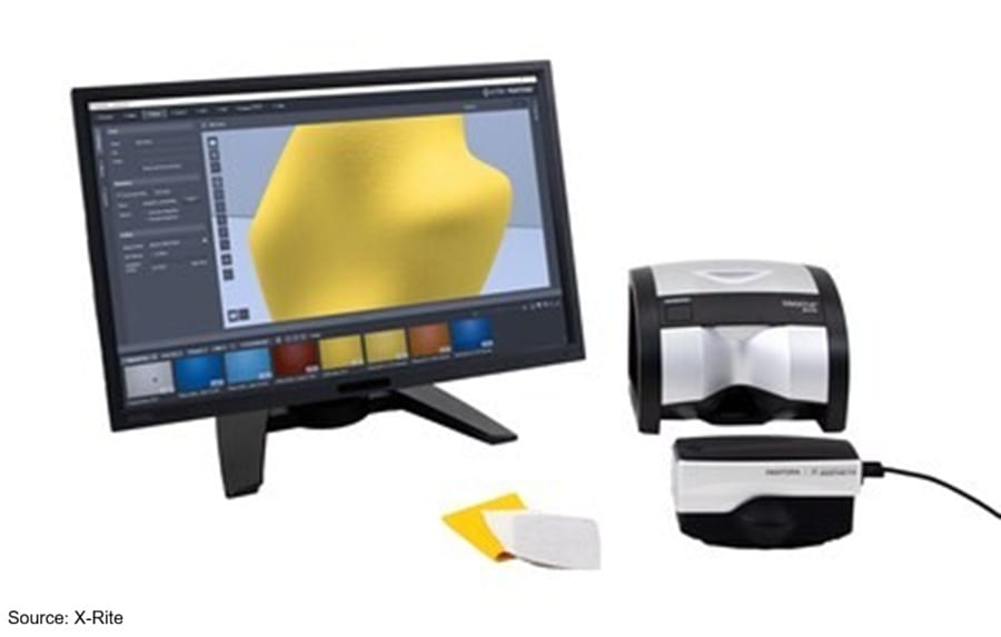 An X-Rite color management system with a monitor displaying 3D rendering, color measurement devices, and swatches.