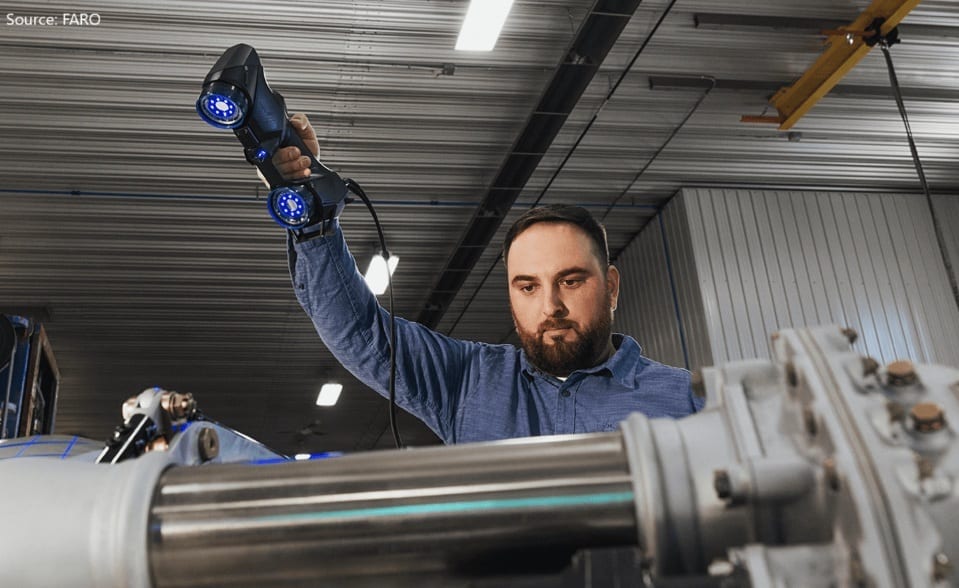 Man uses a FARO 3D scanner to inspect industrial machinery.