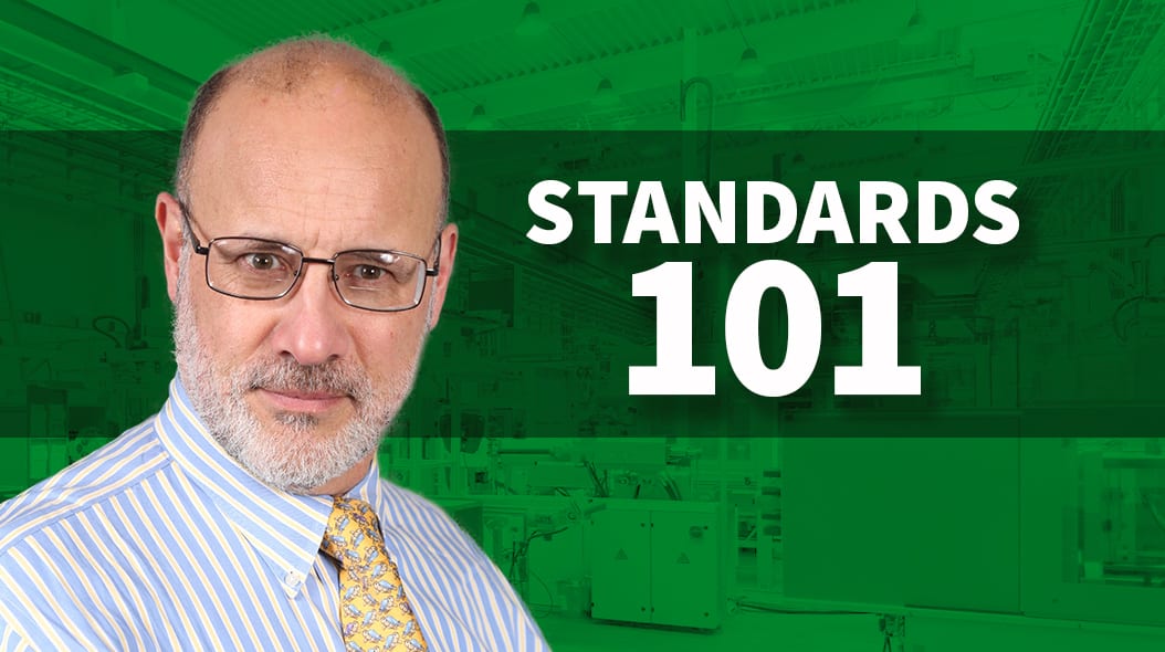 Man with glasses, beard, and "STANDARDS 101" text on a green industrial background.