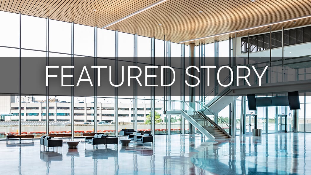 Modern building interior with large windows, seating, and an escalator, overlaid with a 'FEATURED STORY' banner.